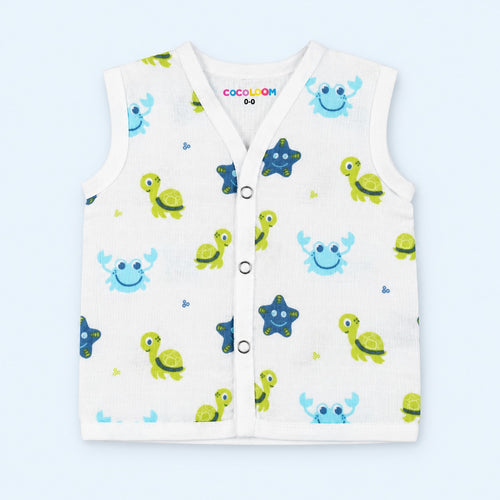 A sleeveless baby vest with a white background and a colorful cartoon sea-creature print, featuring green turtles, blue crabs, and dark blue starfish. It has a snap-button front.