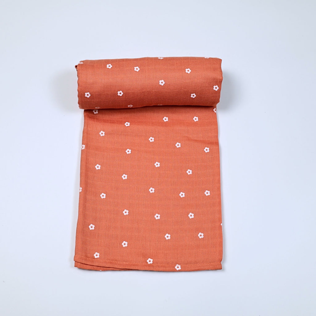Daisy Daze baby bath towel in orange color, printed with white floral patterns