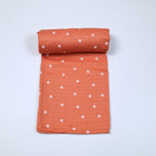 Daisy Daze baby bath towel in orange color, printed with white floral patterns