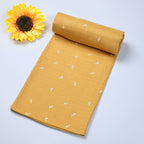 Mustard Sprigs baby bath towel in yellow, printed with white floral pattern