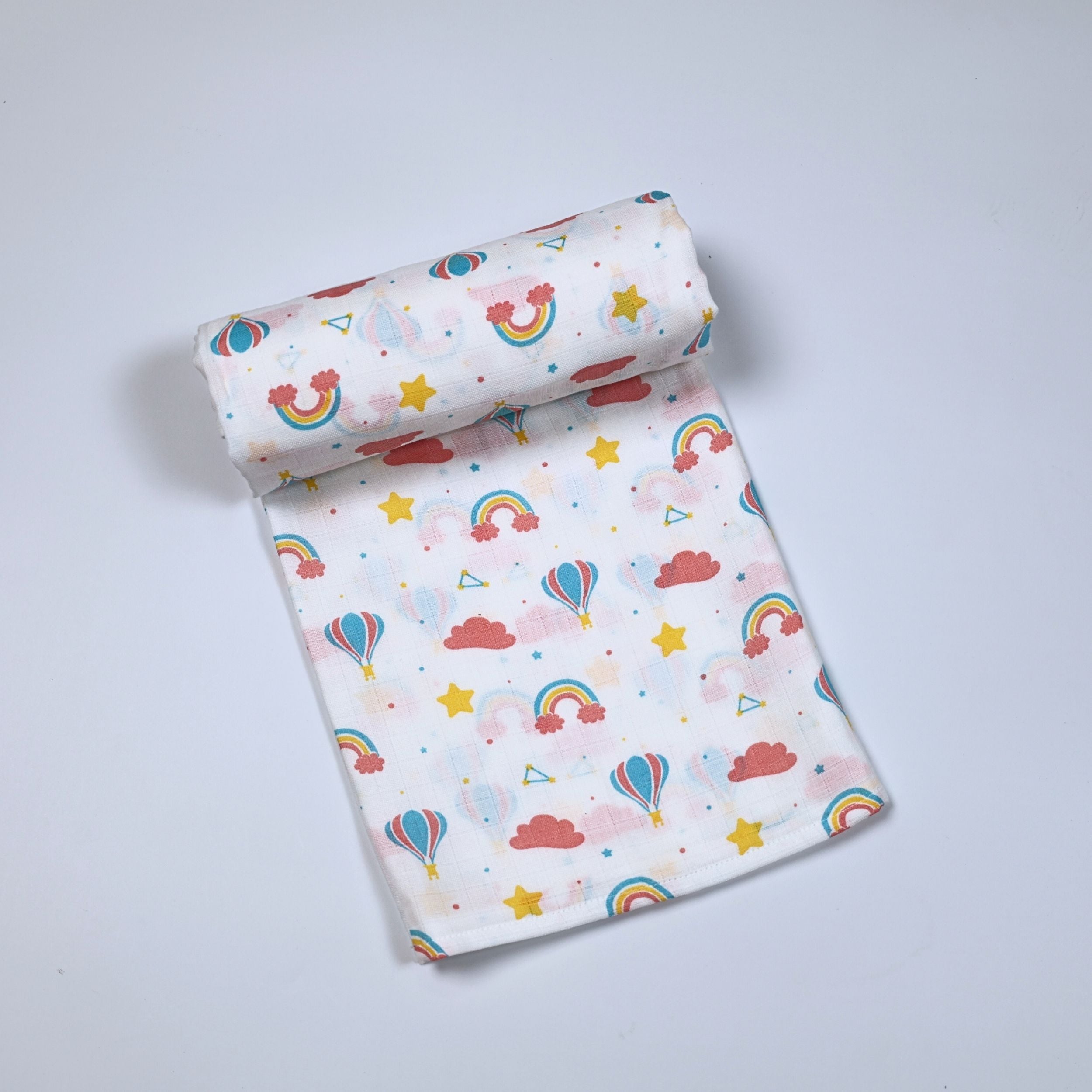 Rainbow Rides Baby bath towel in white printed with rainbow, cloud, and hot air balloon pattern