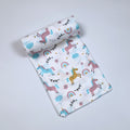 Unicorn baby bath towel in white, printed with unicorn and rainbow patterns