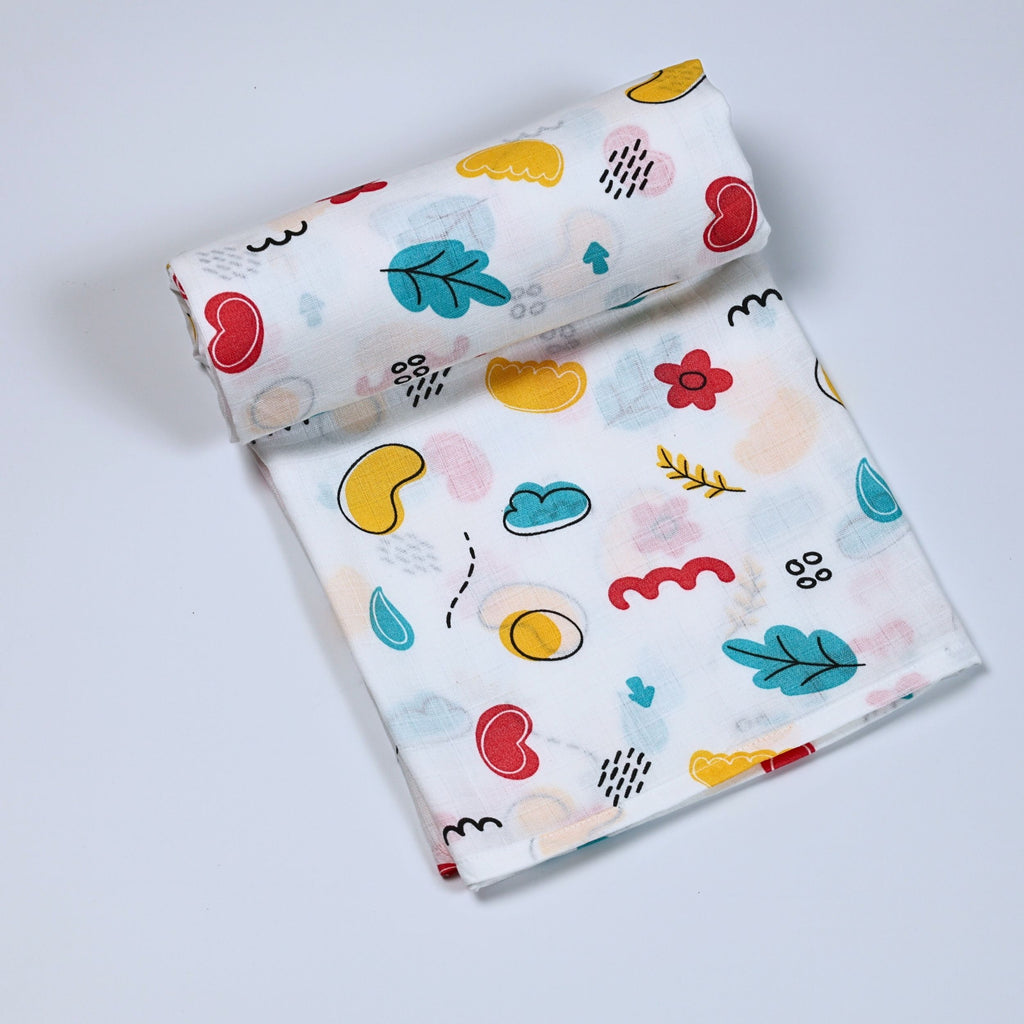 Wild Doodles Baby bath towel in white printed with yellow, red and pastel green scribble patterns.