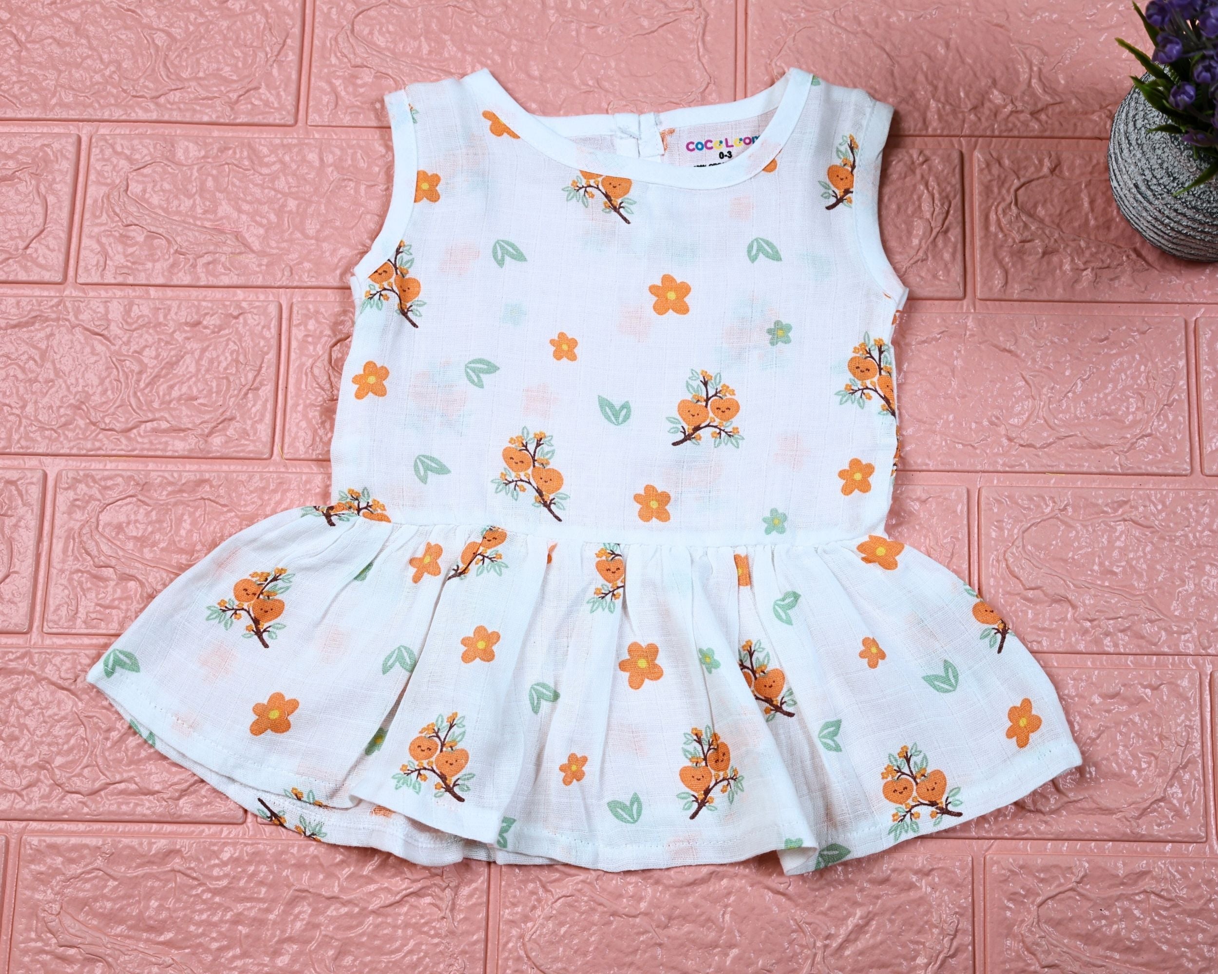 Citrus Bloom Baby sleeveless frock in white with button, printed with orange floral patterns
