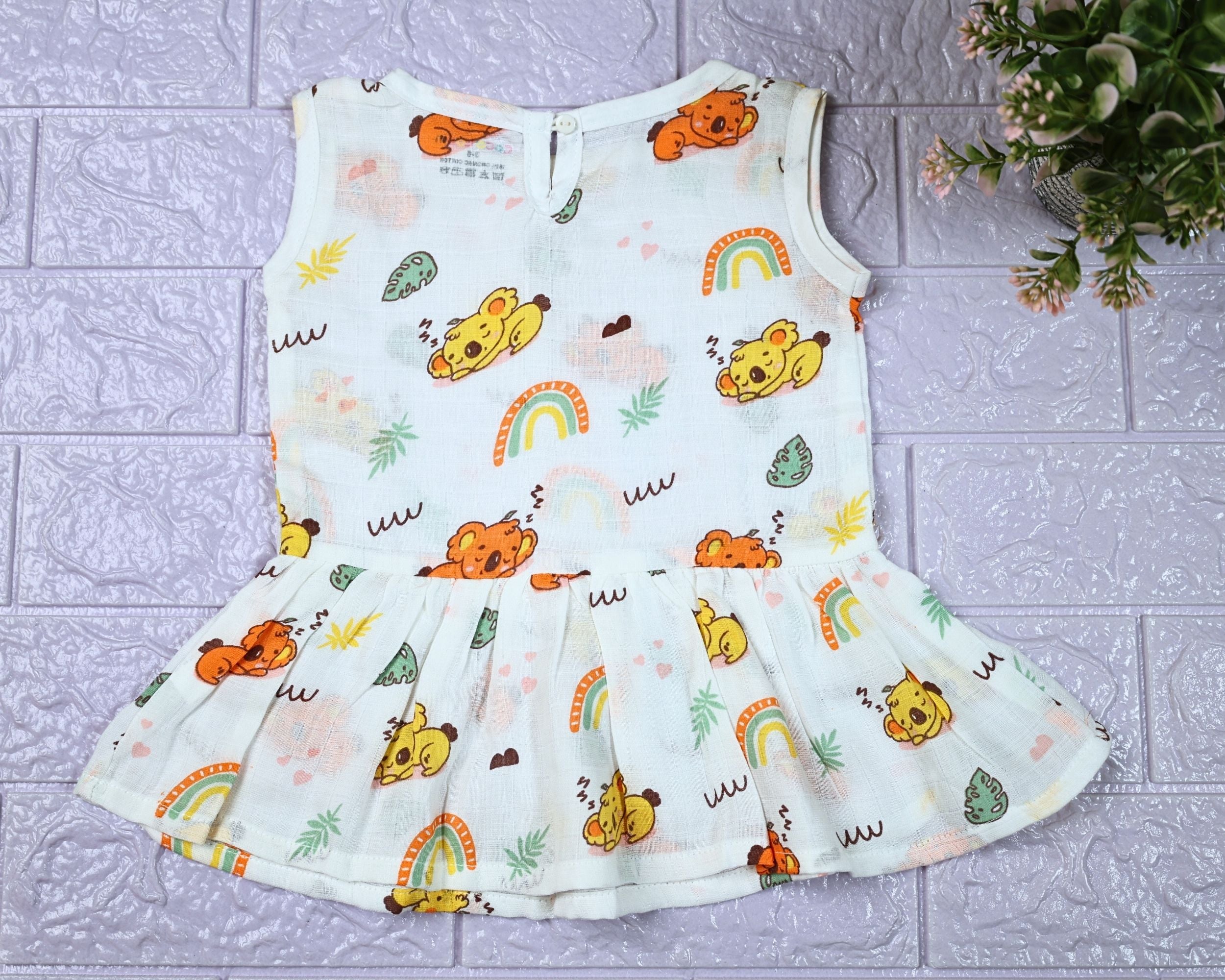 Koala Dreams baby sleeveless frock in white with button printed with bear and rainbow pattern