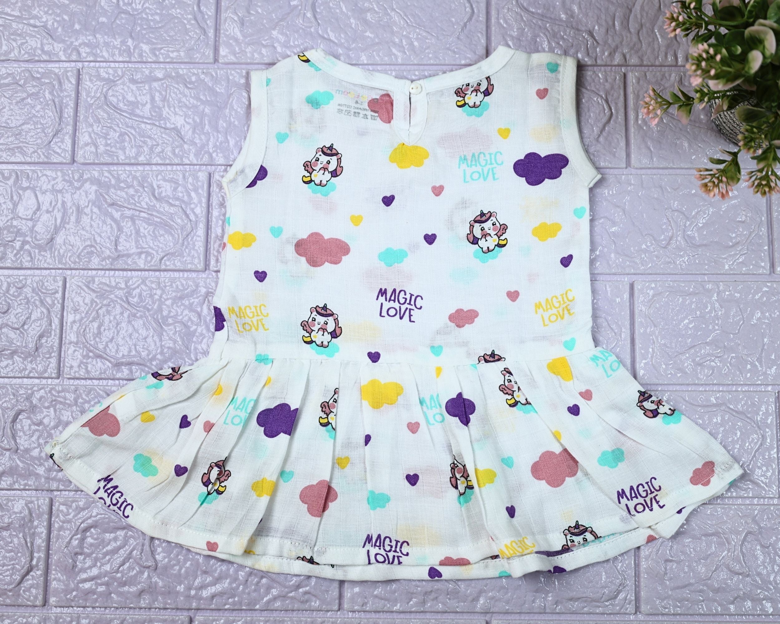 Purple Magic baby sleeveless frock in white with button, printed with colourful patterns