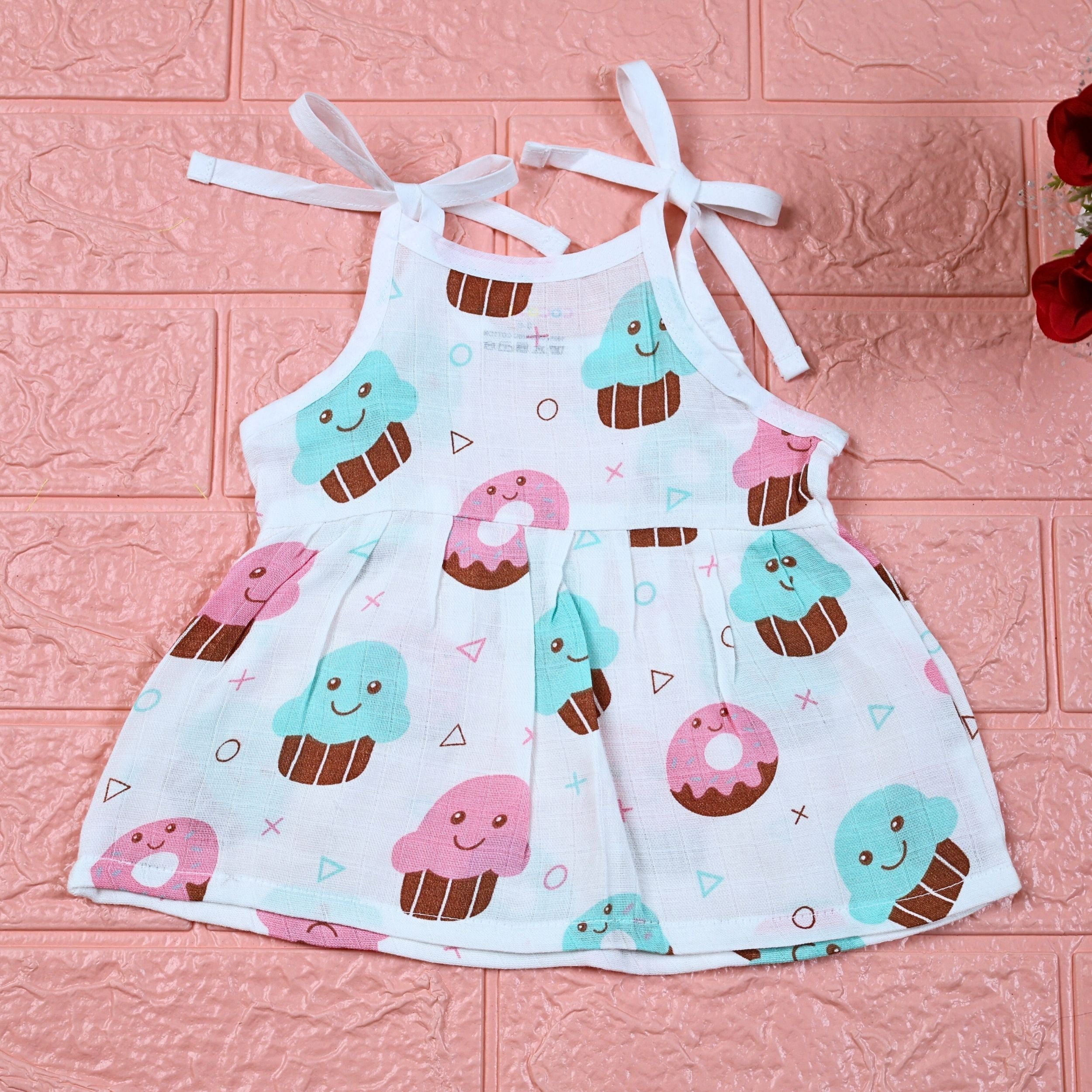 Sugar Rush baby frock in white printed with tie up shoulders, printed with cup cakes