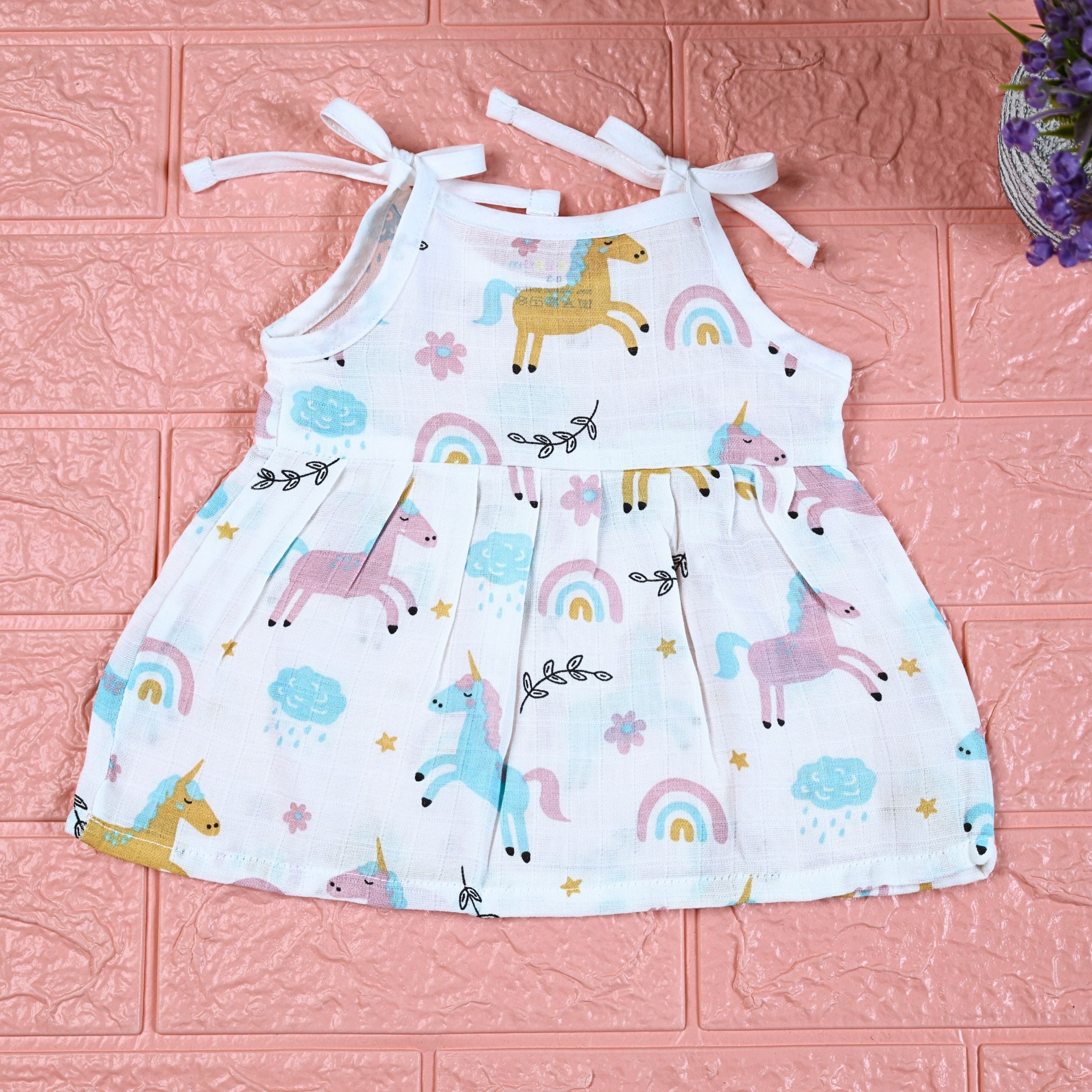 Unicorn baby sleeveless frock in white with tie up shoulders, printed with unicorn and rainbow patterns