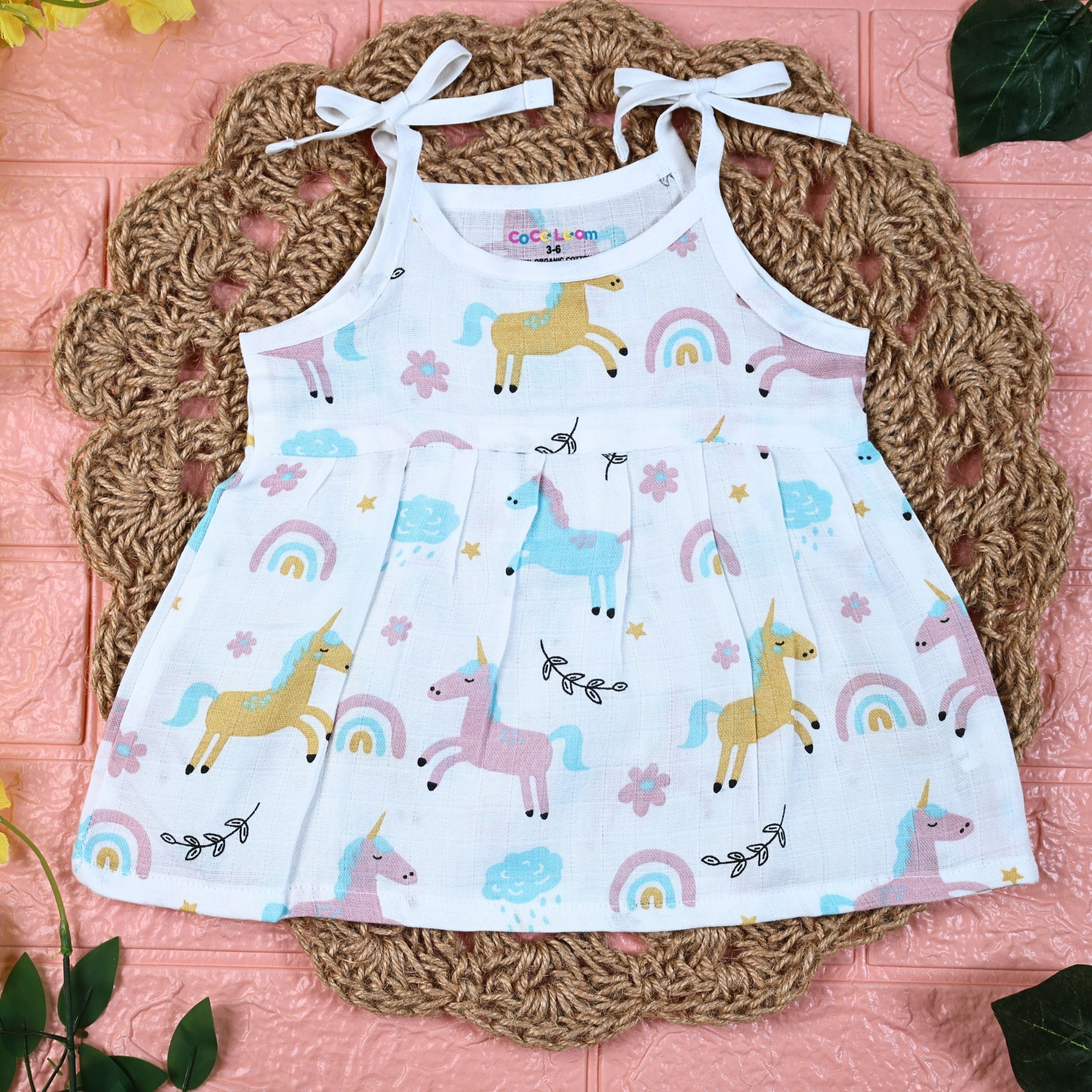 Unicorn baby sleeveless frock in white with tie up shoulders, printed with unicorn and rainbow patterns