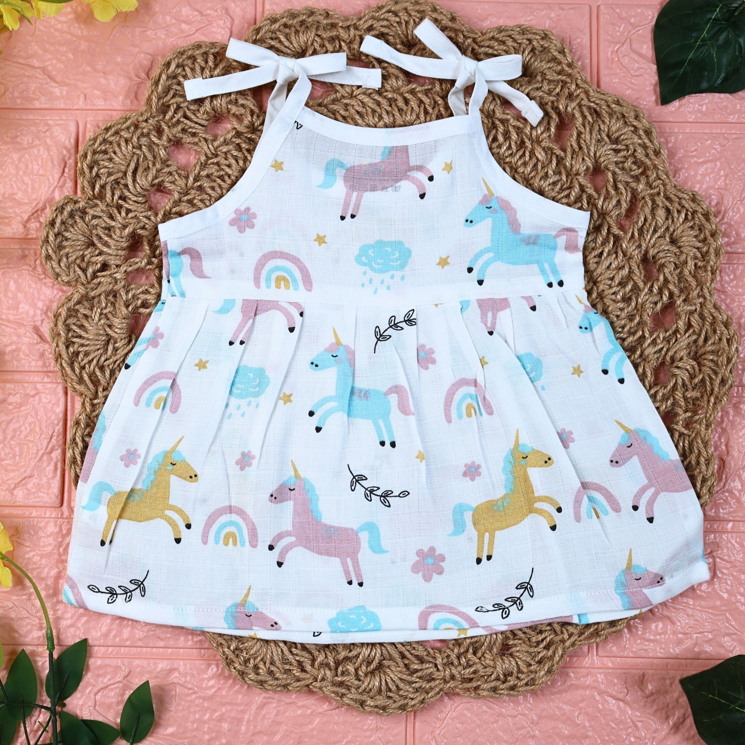 Unicorn baby sleeveless frock in white with tie up shoulders, printed with unicorn and rainbow patterns