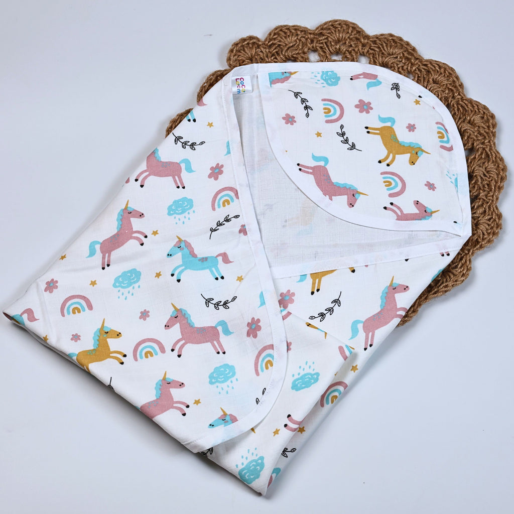 Unicorn baby hooded towel in white, printed with unicorn and rainbow patterns