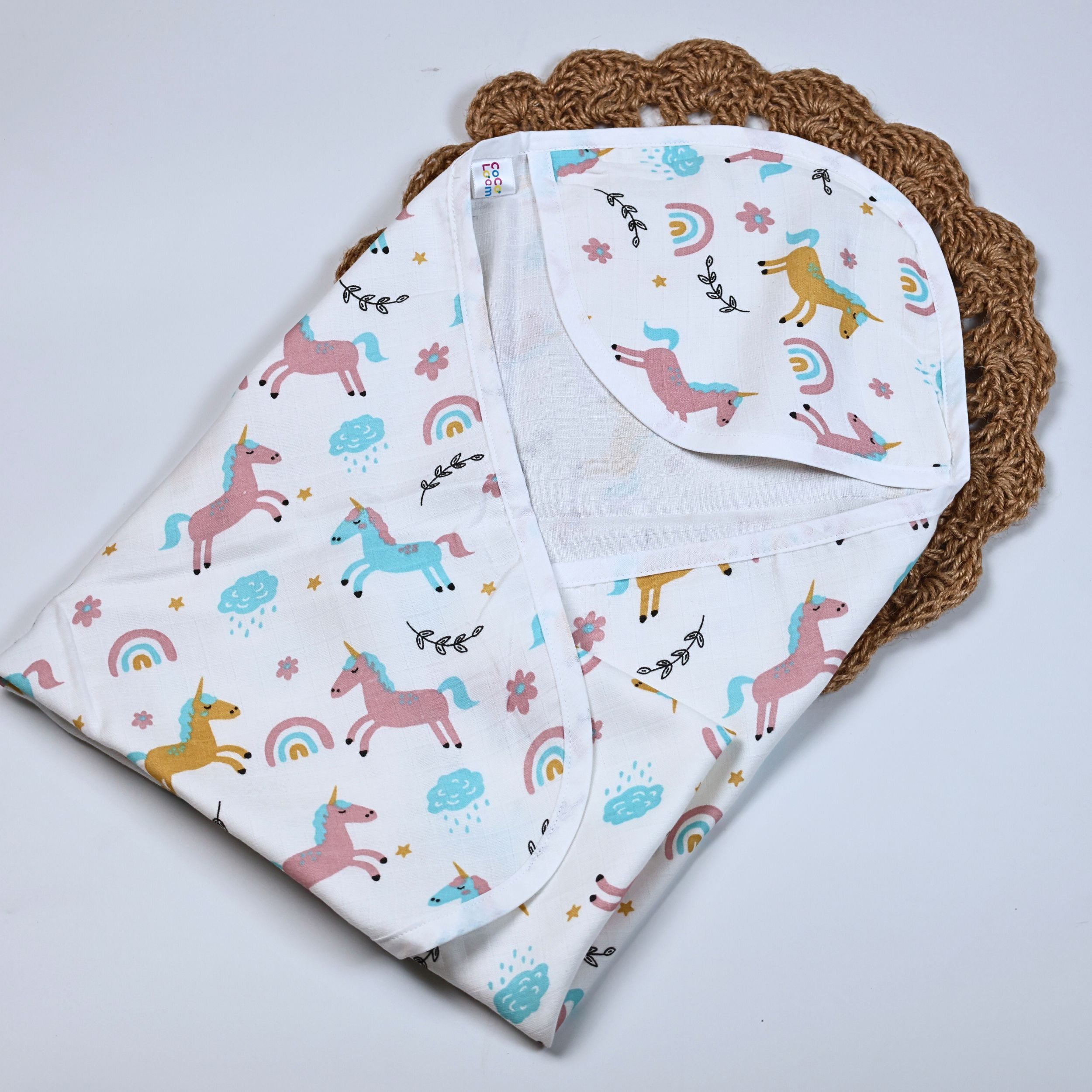 Unicorn baby hooded towel in white, printed with unicorn and rainbow patterns