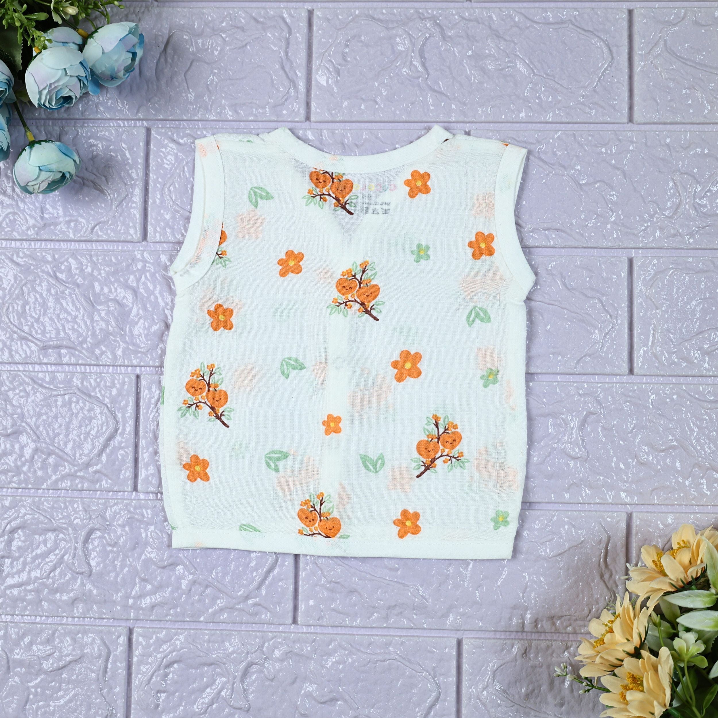 Citrus Bloom Baby sleeveless top in white with snap buttons, printed with orange floral patterns