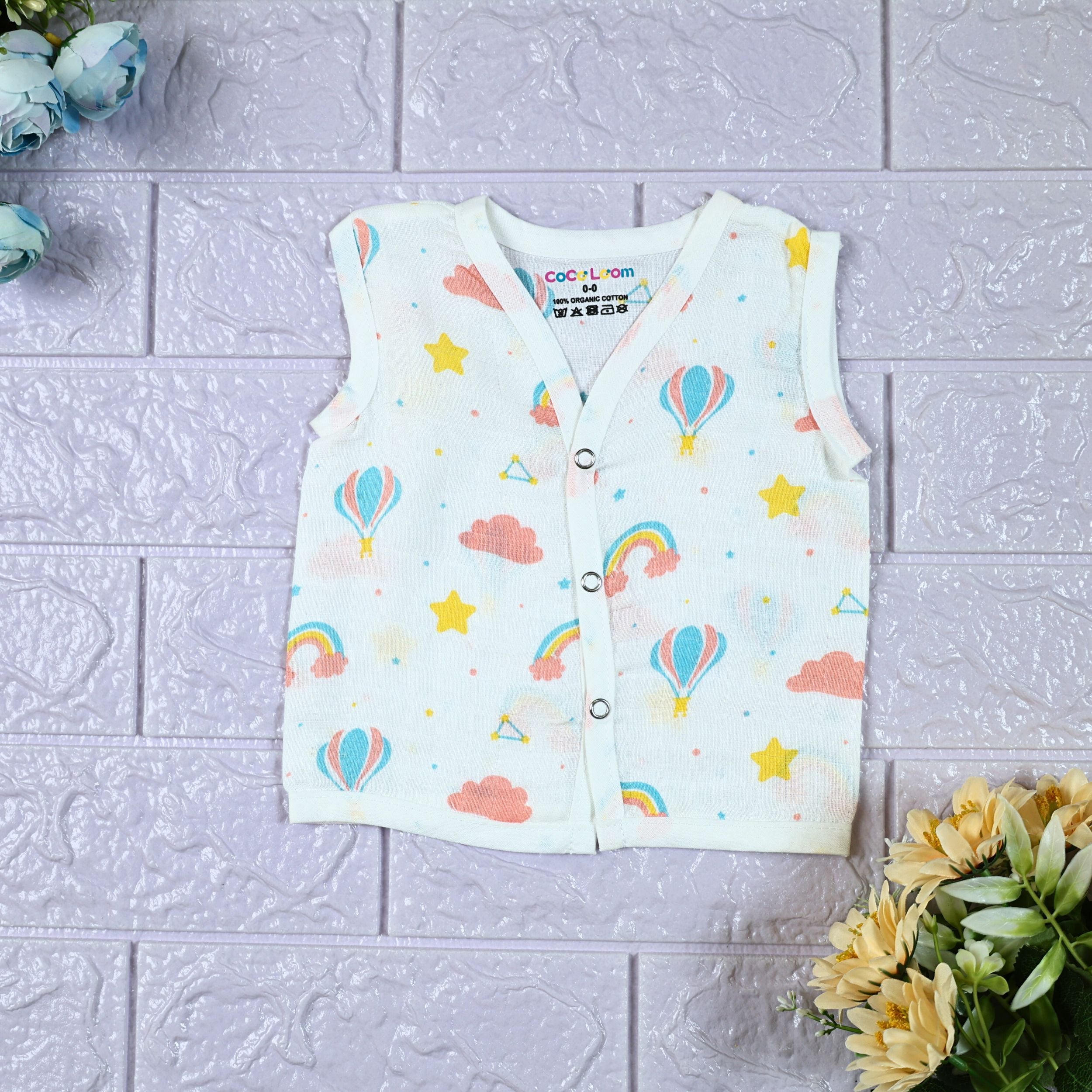 Rainbow Rides baby sleeveless top in white with snap buttons, printed with rainbows, air balloons, clouds, and stars.