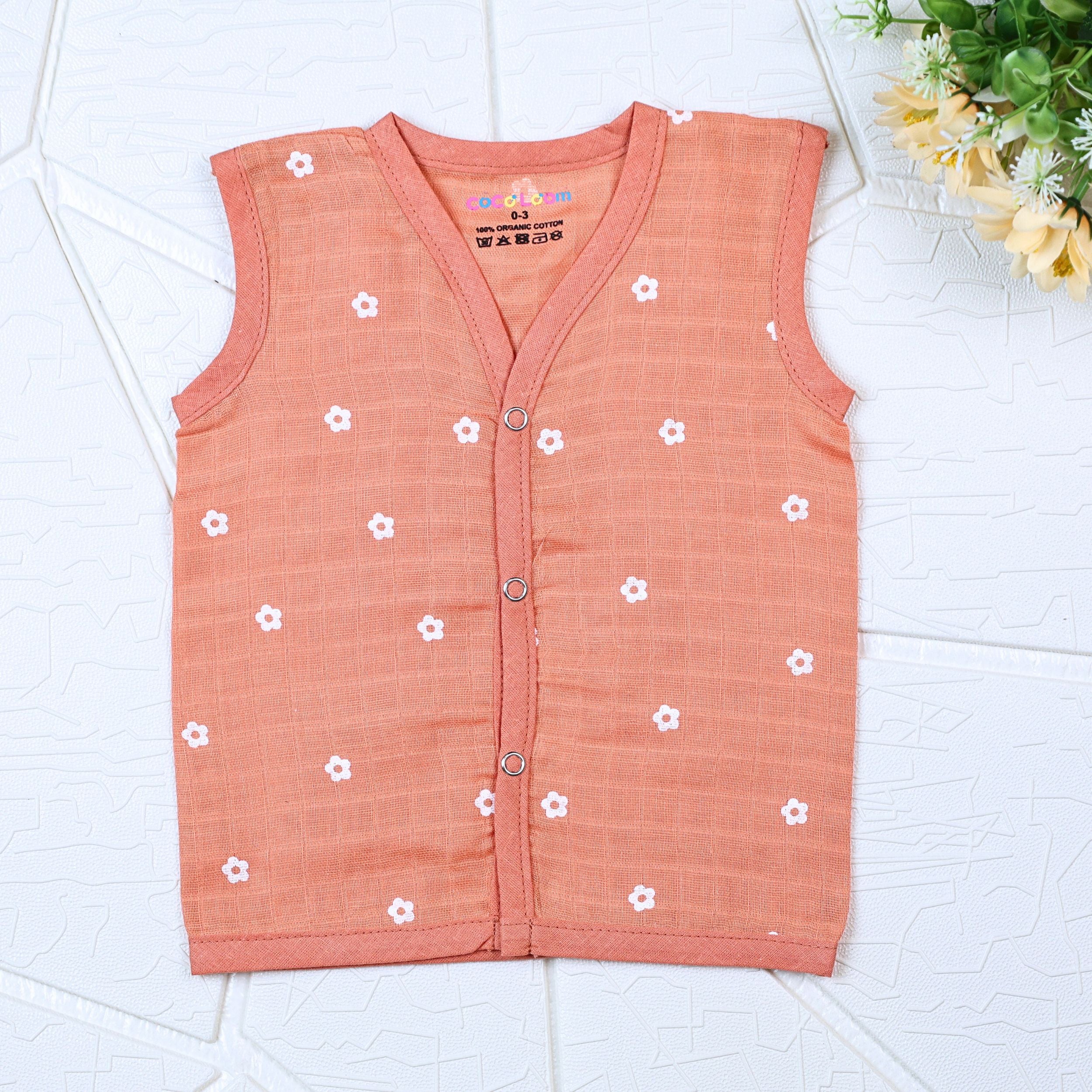 Daisy Daze baby sleeveless top in orange color with snap buttons printed with white floral patterns