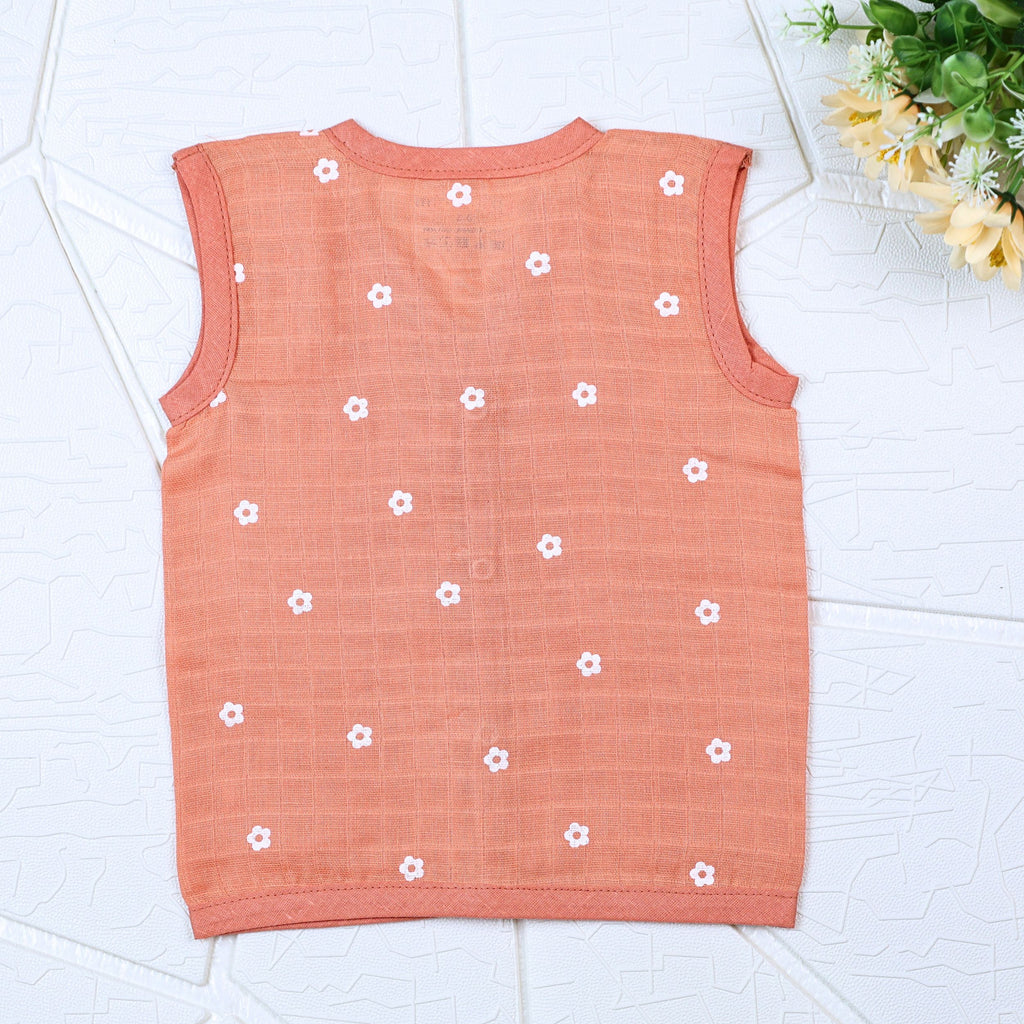 Daisy Daze baby sleeveless top in orange color with snap buttons printed with white floral patterns