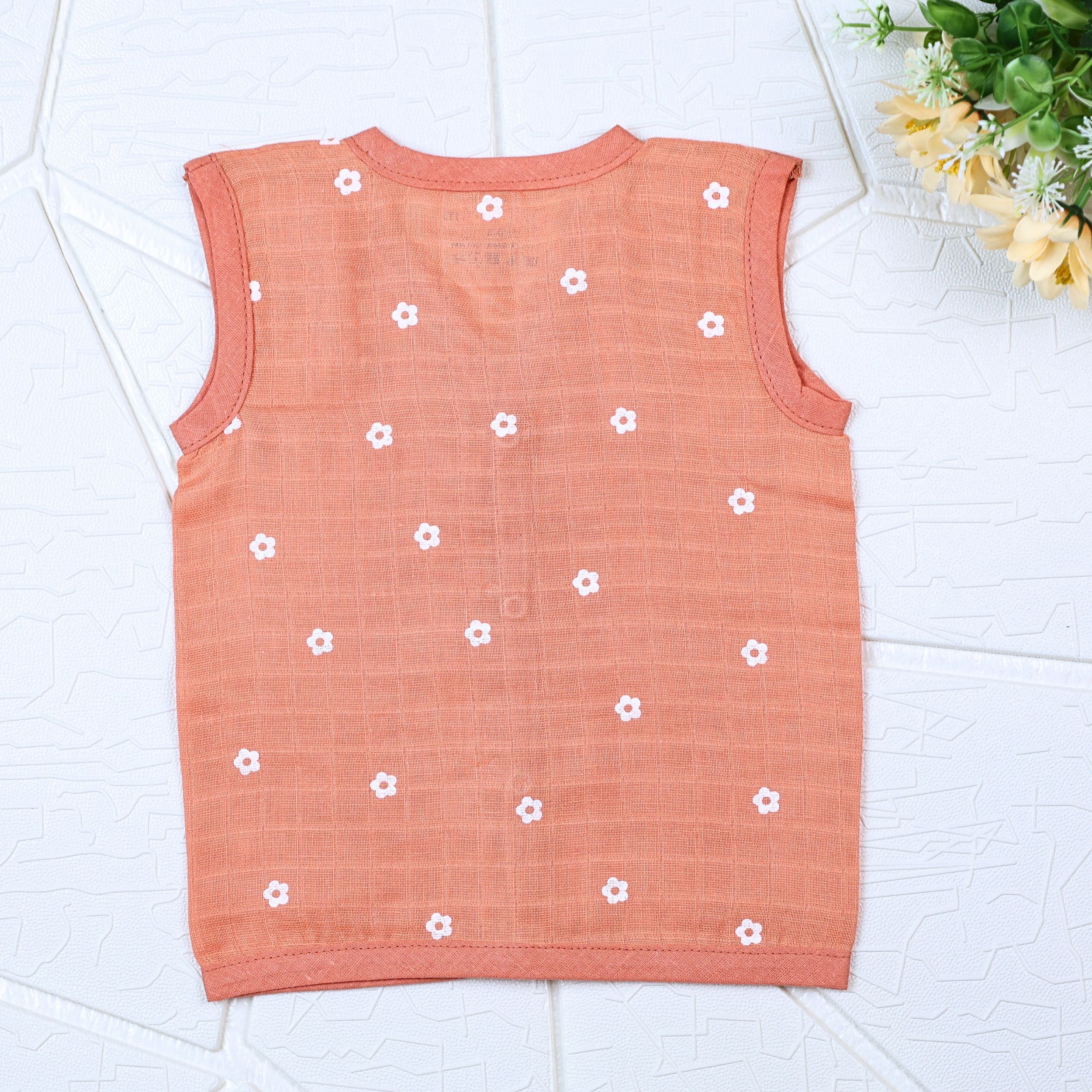 Daisy Daze baby sleeveless top in orange color with snap buttons printed with white floral patterns