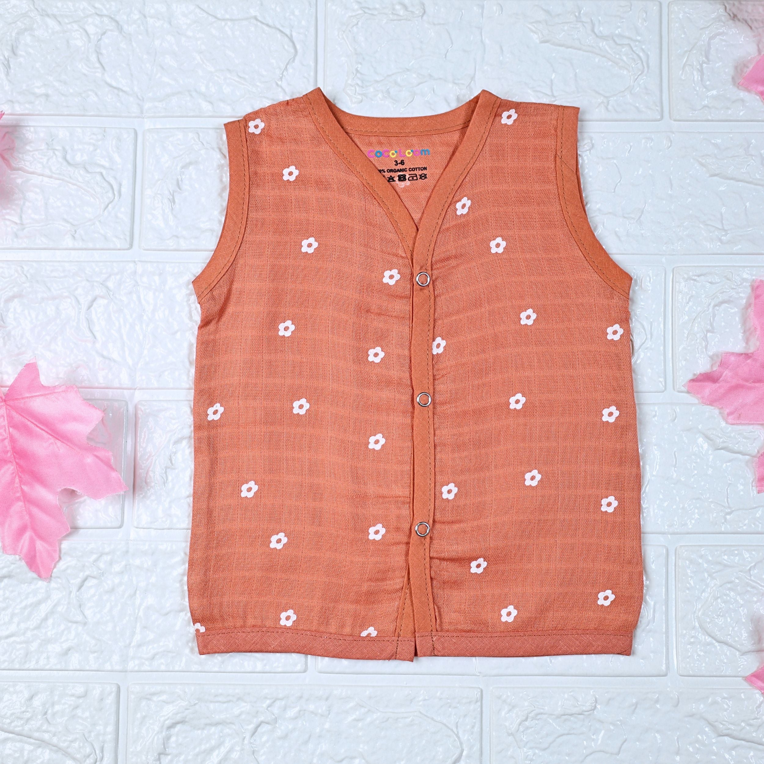 Daisy Daze baby top in orange color with snap buttons printed with white floral patterns