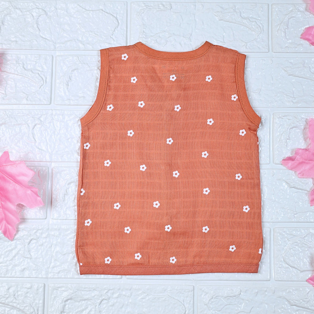 Daisy Daze baby top in orange color with snap buttons printed with white floral patterns