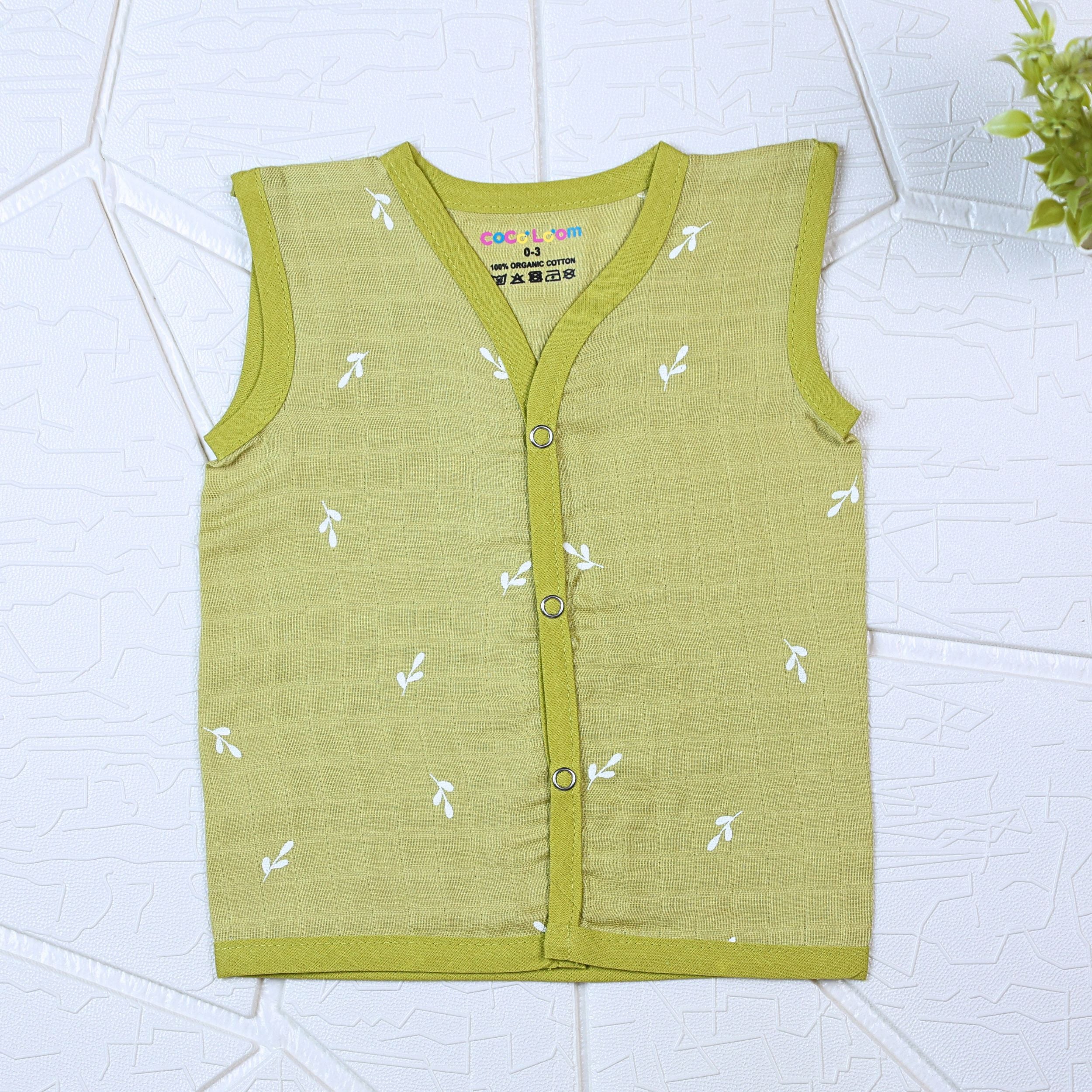 Green Twigs baby sleeveless top in green with snap buttons printed with white floral patterns