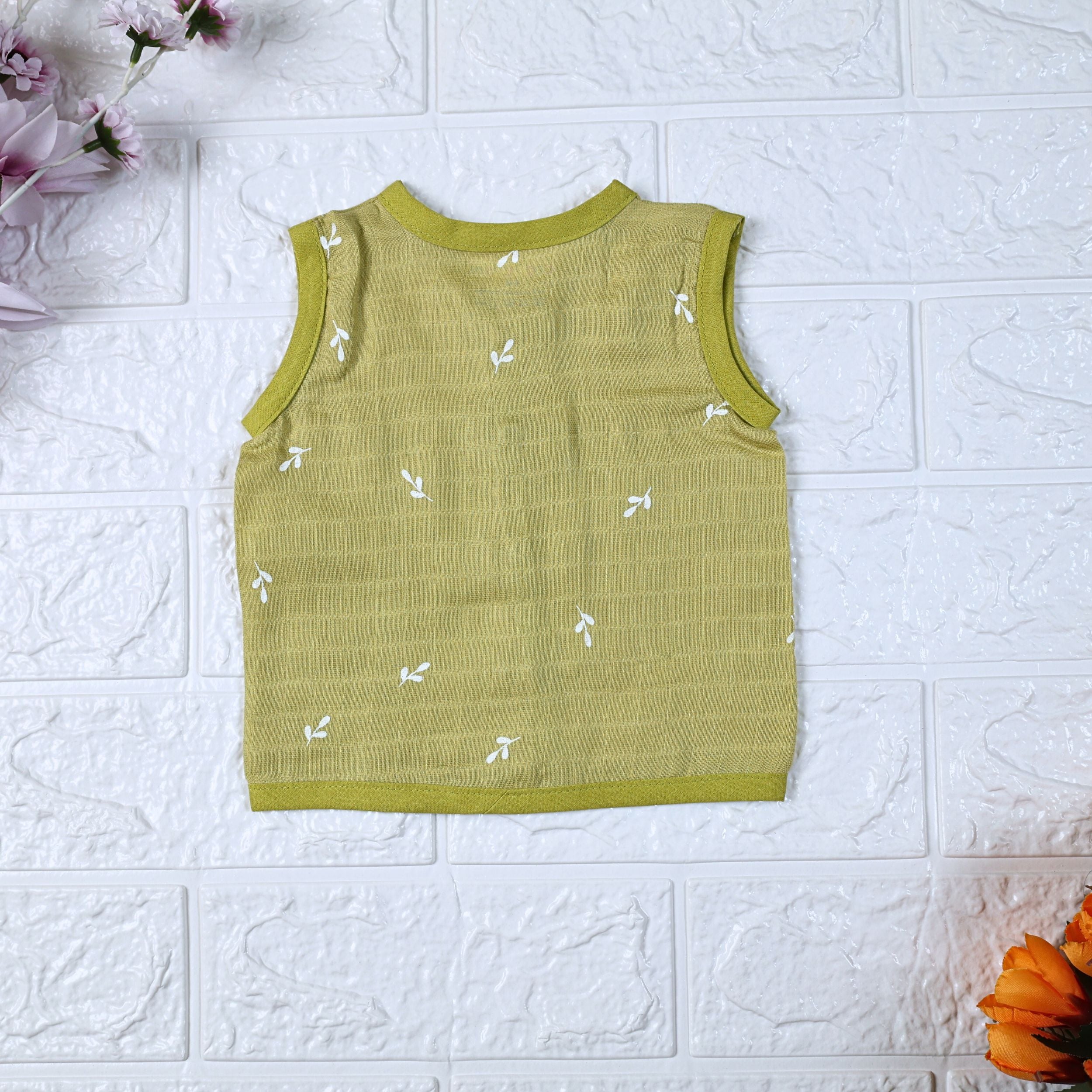 Green Twigs baby sleeveless top in green with snap buttons printed with white floral patterns