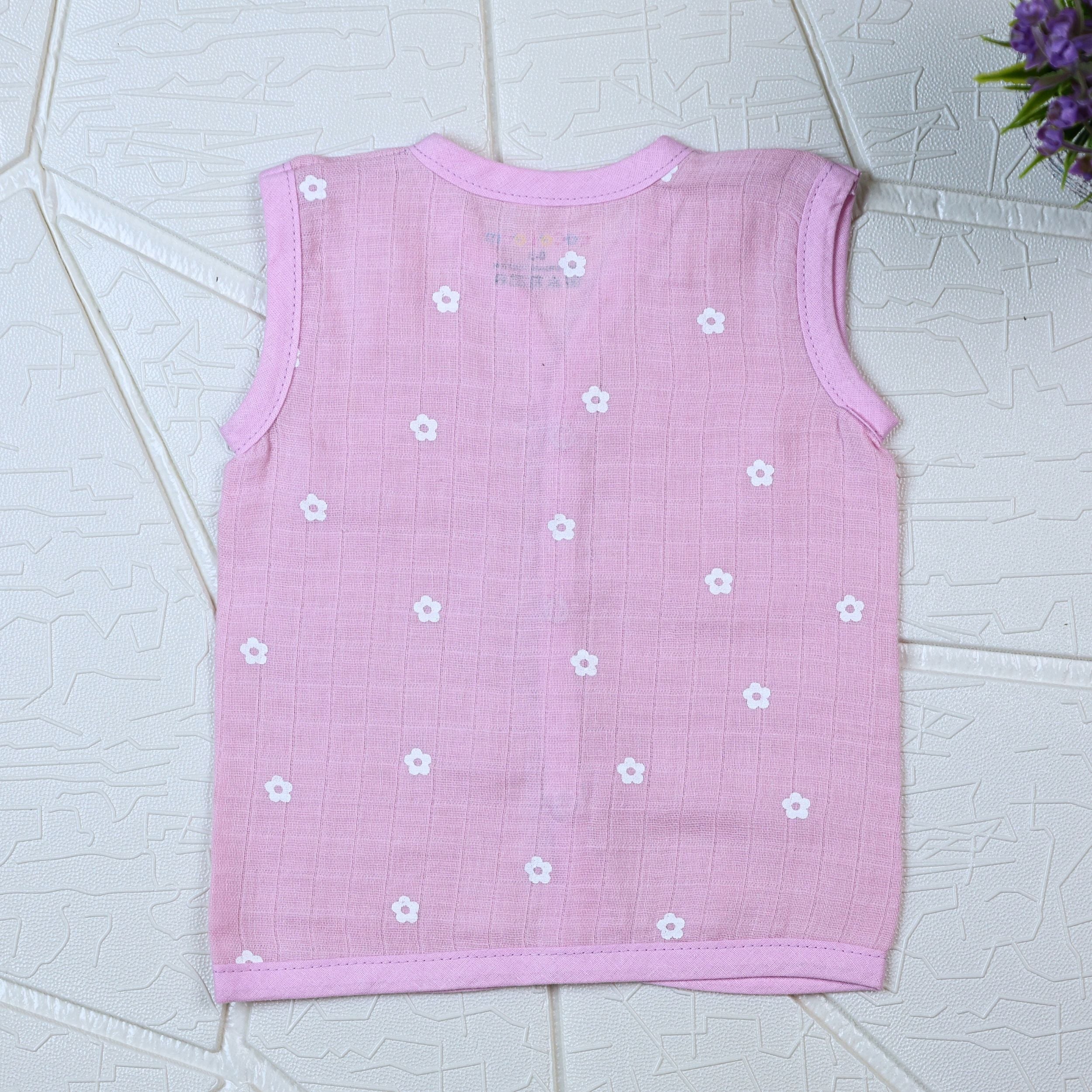 Pink Daisy baby sleeveless top in pink with snap buttons printed with white floral patterns