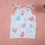 Butterfly Blush baby top in white with tie-up shoulders, printed with pastel butterfly motifs in soft pink and blue tones.