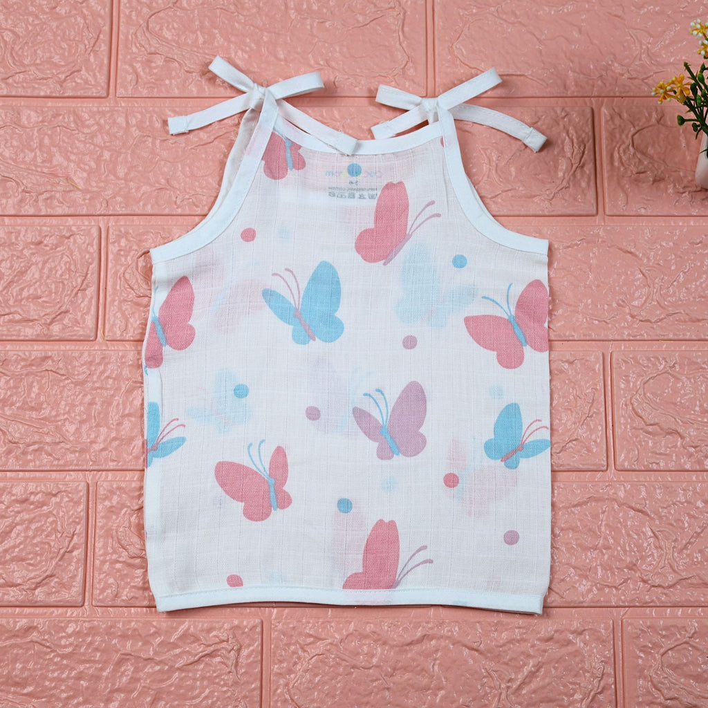 Butterfly Blush baby top in white with tie-up shoulders, printed with pastel butterfly motifs in soft pink and blue tones.