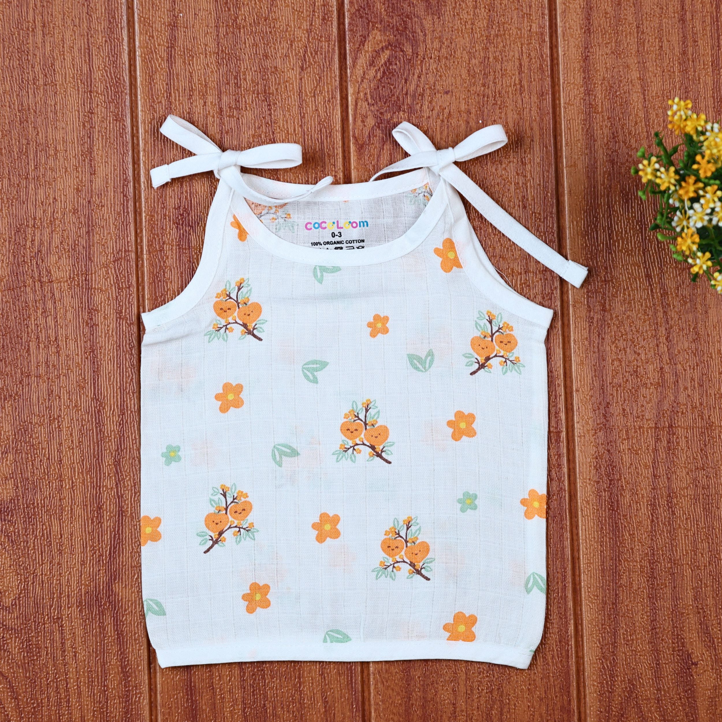 Citrus Bloom top in white with shoulder knot, printed with orange floral patterns