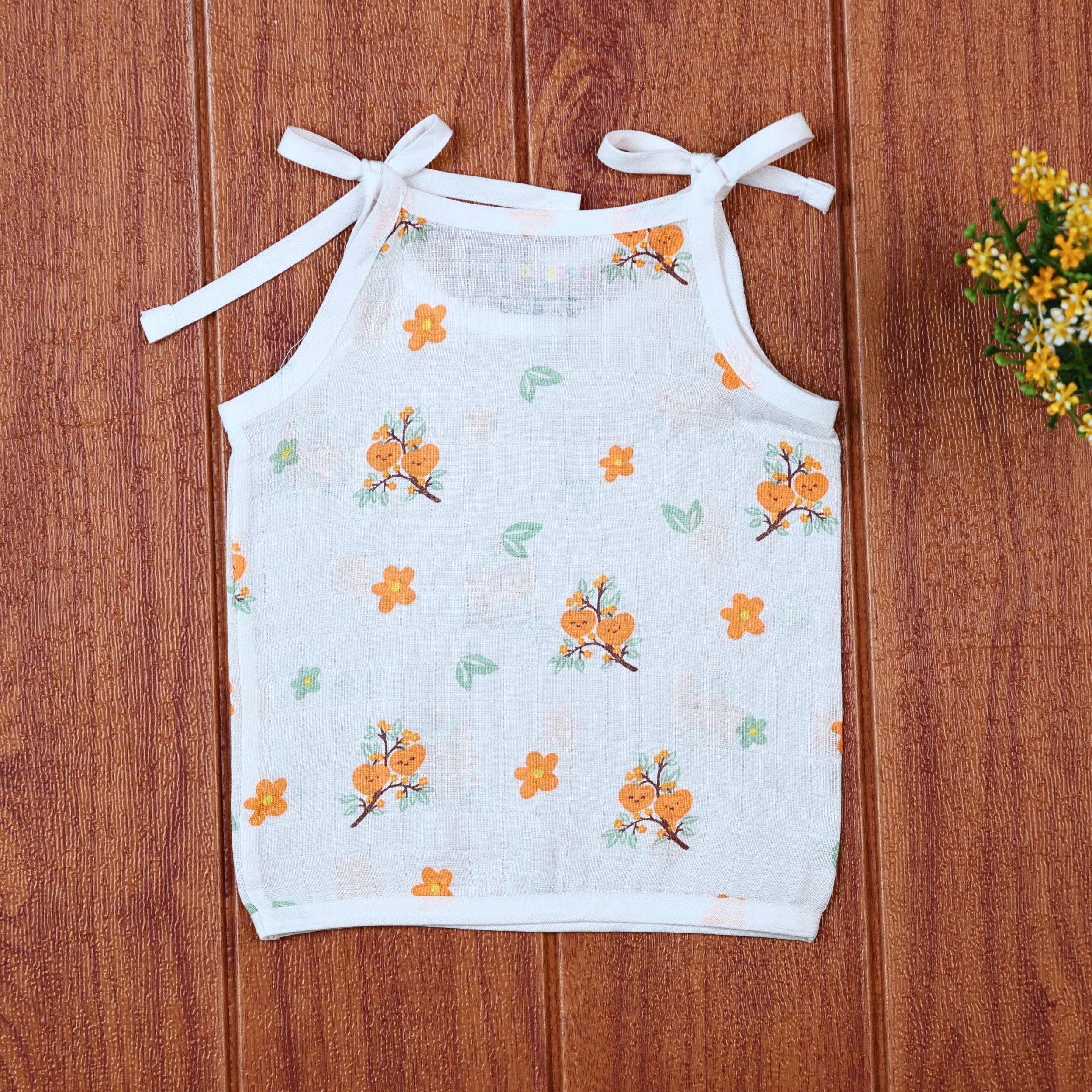 Citrus Bloom top in white with shoulder knot, printed with orange floral patterns