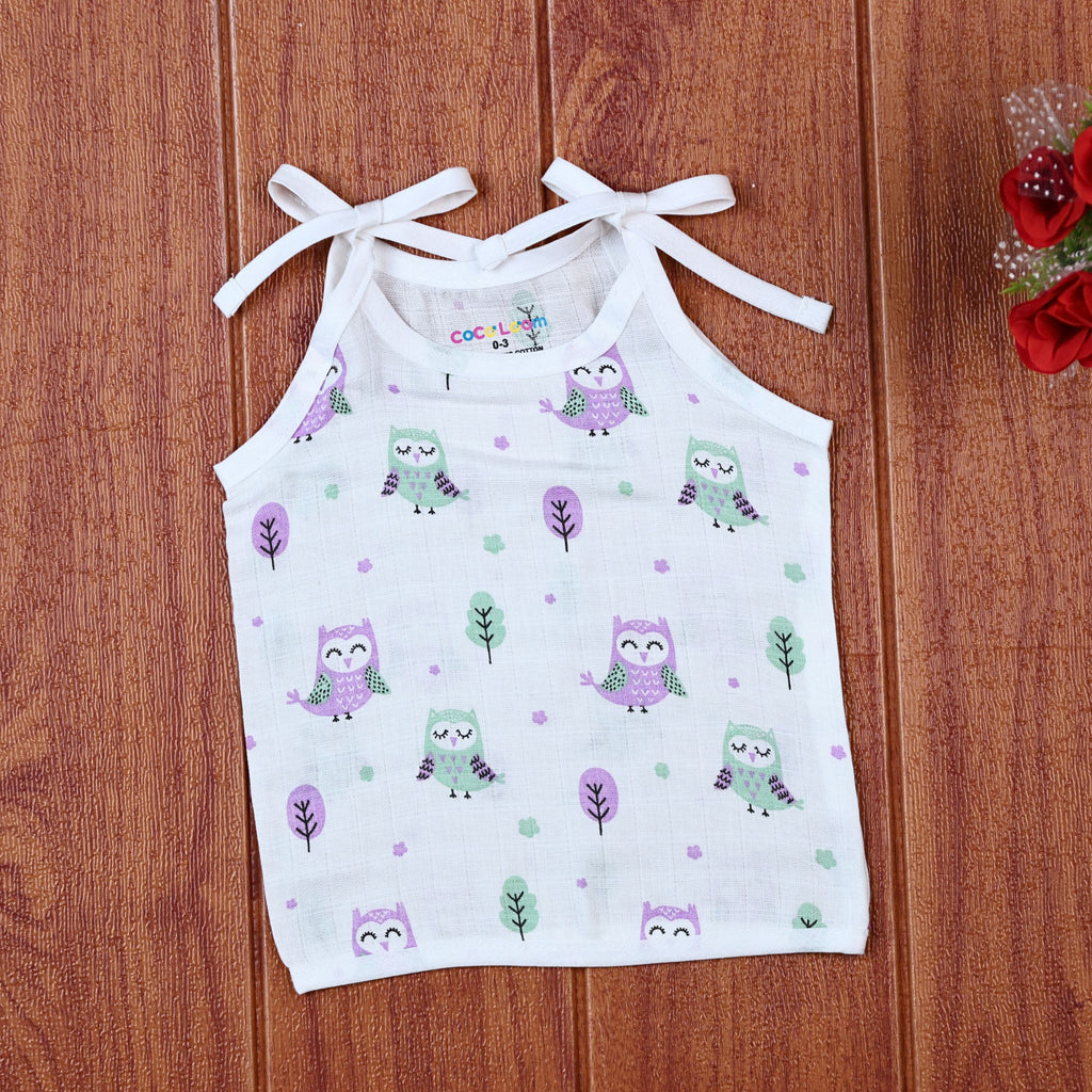 Little Hoots baby top in white with shoulder tie ups, printed with purple and green owl patterns
