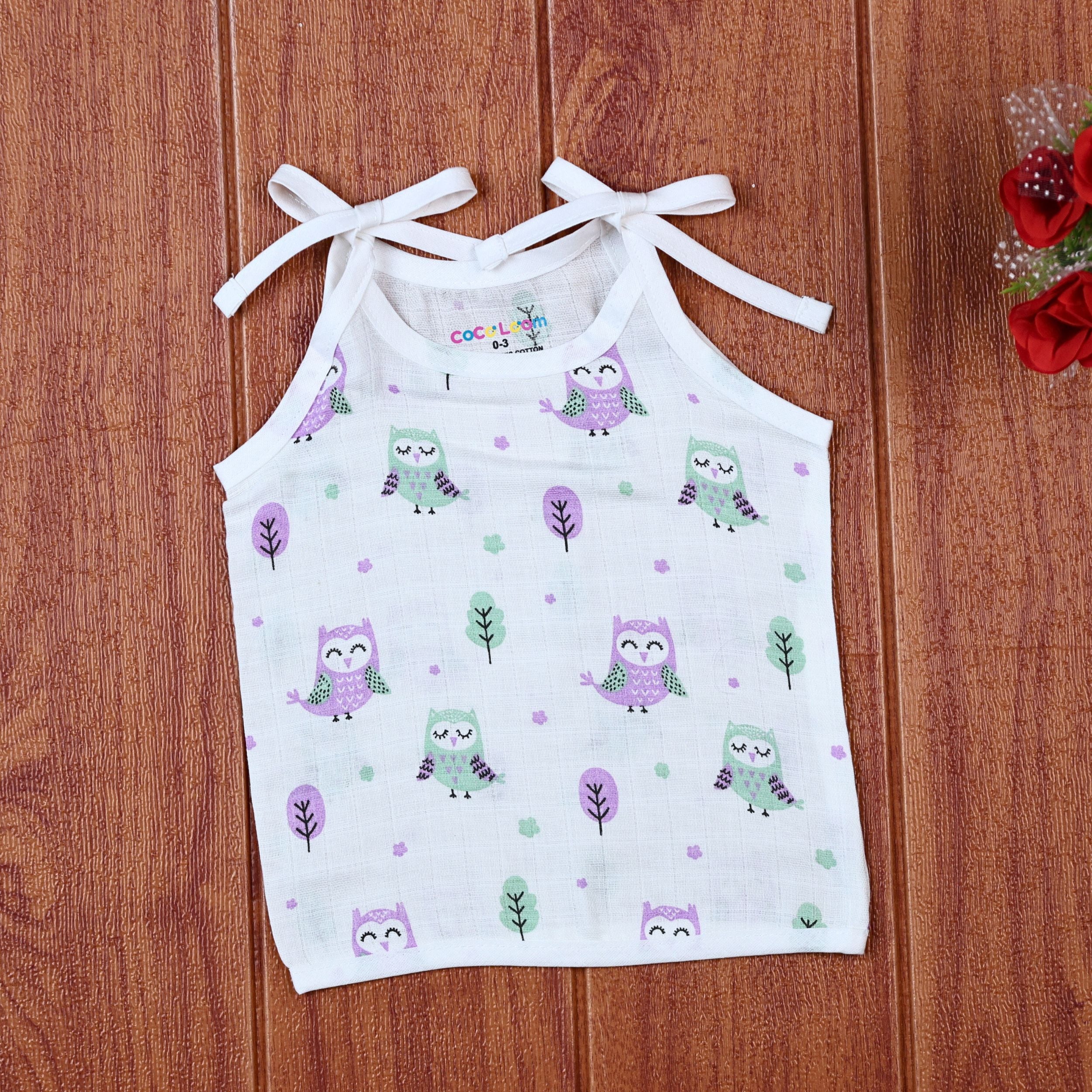 Little Hoots baby top in white with shoulder tie ups, printed with purple and green owl patterns