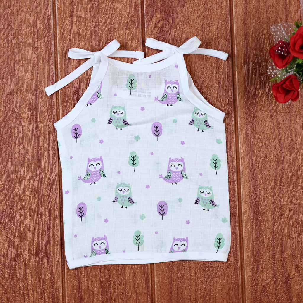Little Hoots baby top in white with shoulder tie ups, printed with purple and green owl patterns
