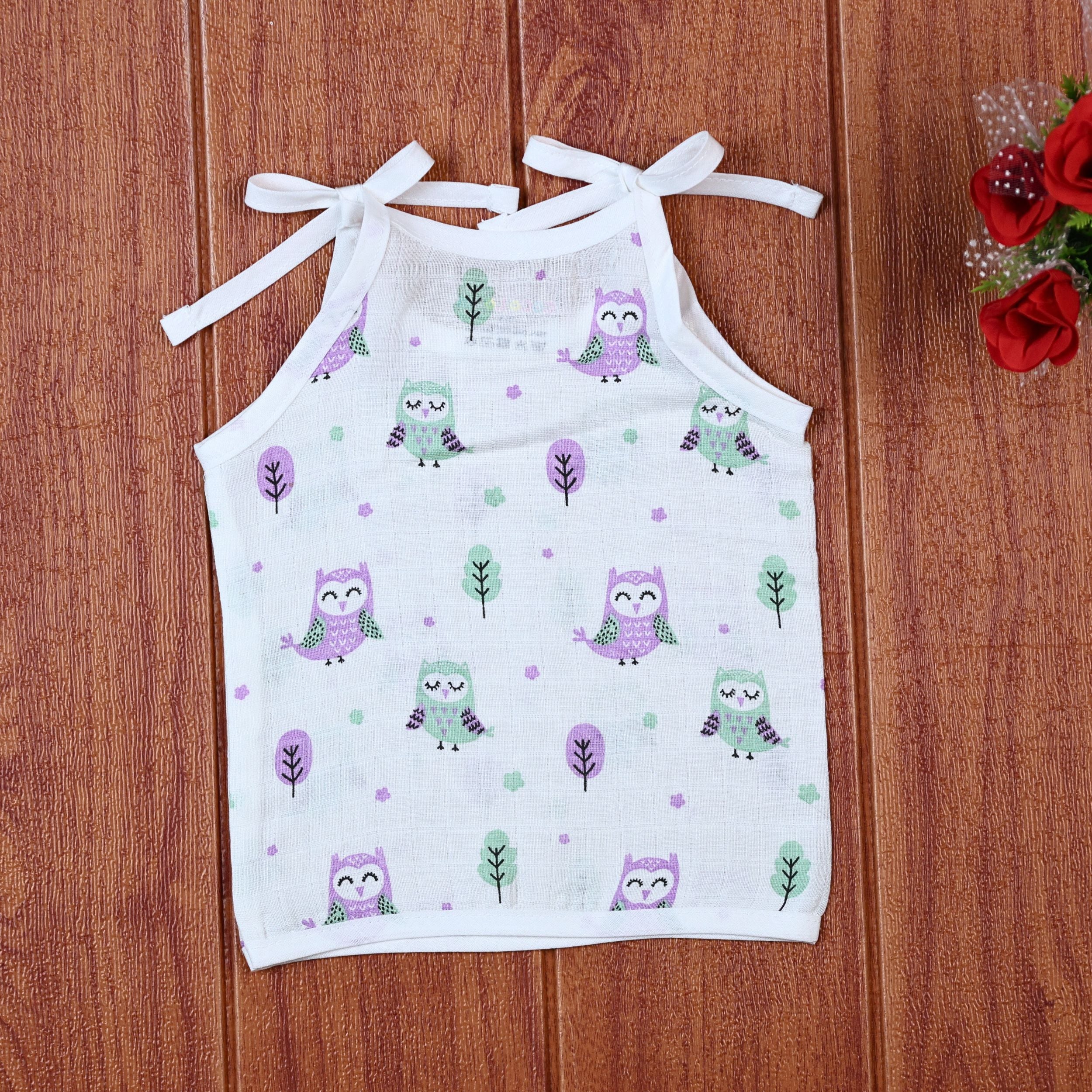 Little Hoots baby top in white with shoulder tie ups, printed with purple and green owl patterns