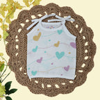 Love Lines baby top in white with tie up shoulders, printed with pastel pink, green and yellow heart patterns
