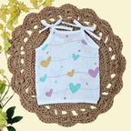 Love Lines baby top in white with tie up shoulders, printed with pastel pink, green and yellow heart patterns