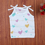 Love Lines baby top in white with tie up shoulders, printed with pastel pink, green and yellow heart patterns