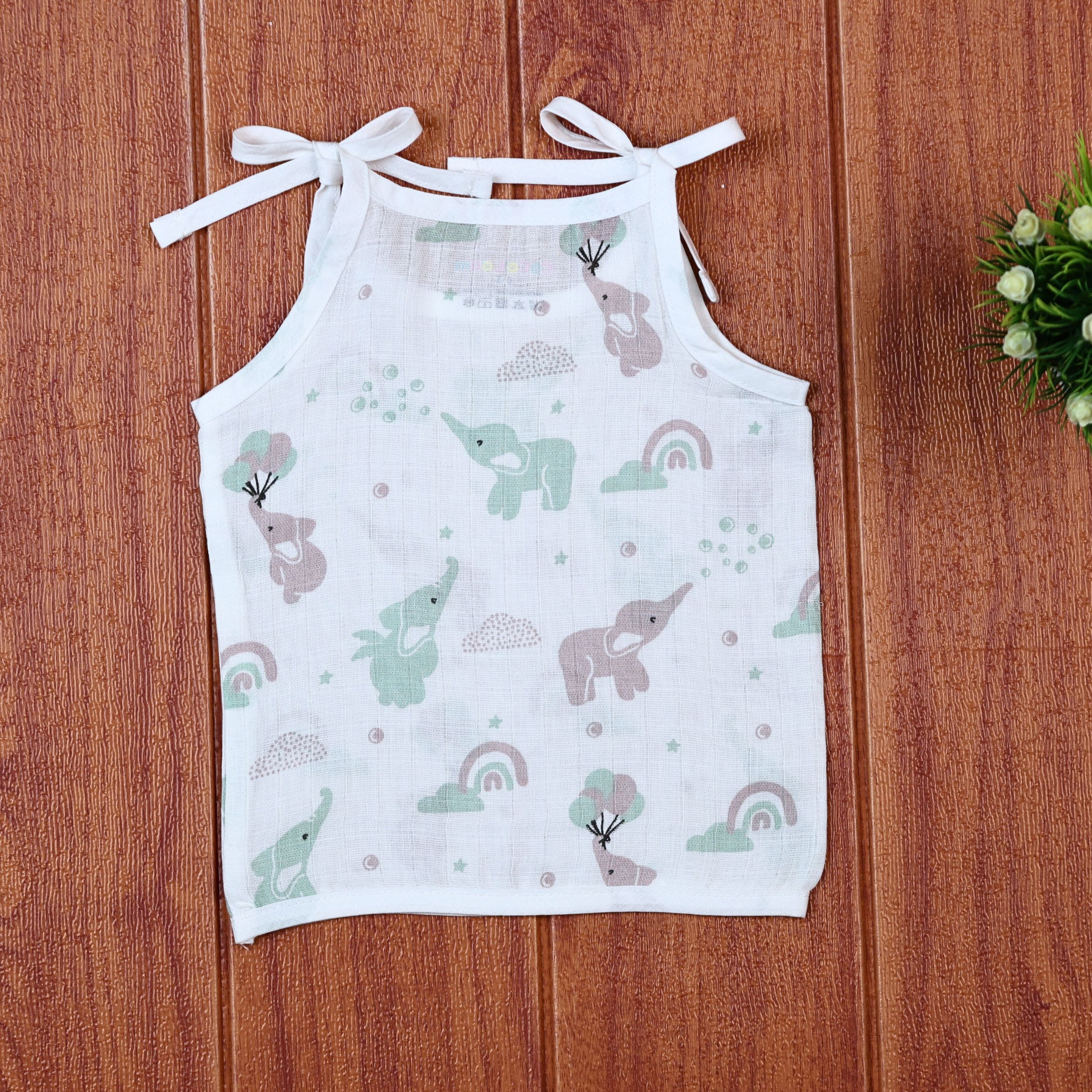Tiny Tusks baby top in white with shoulder knots, with elephant, clouds and rainbow
 prints in gentle green and brown
 shades.