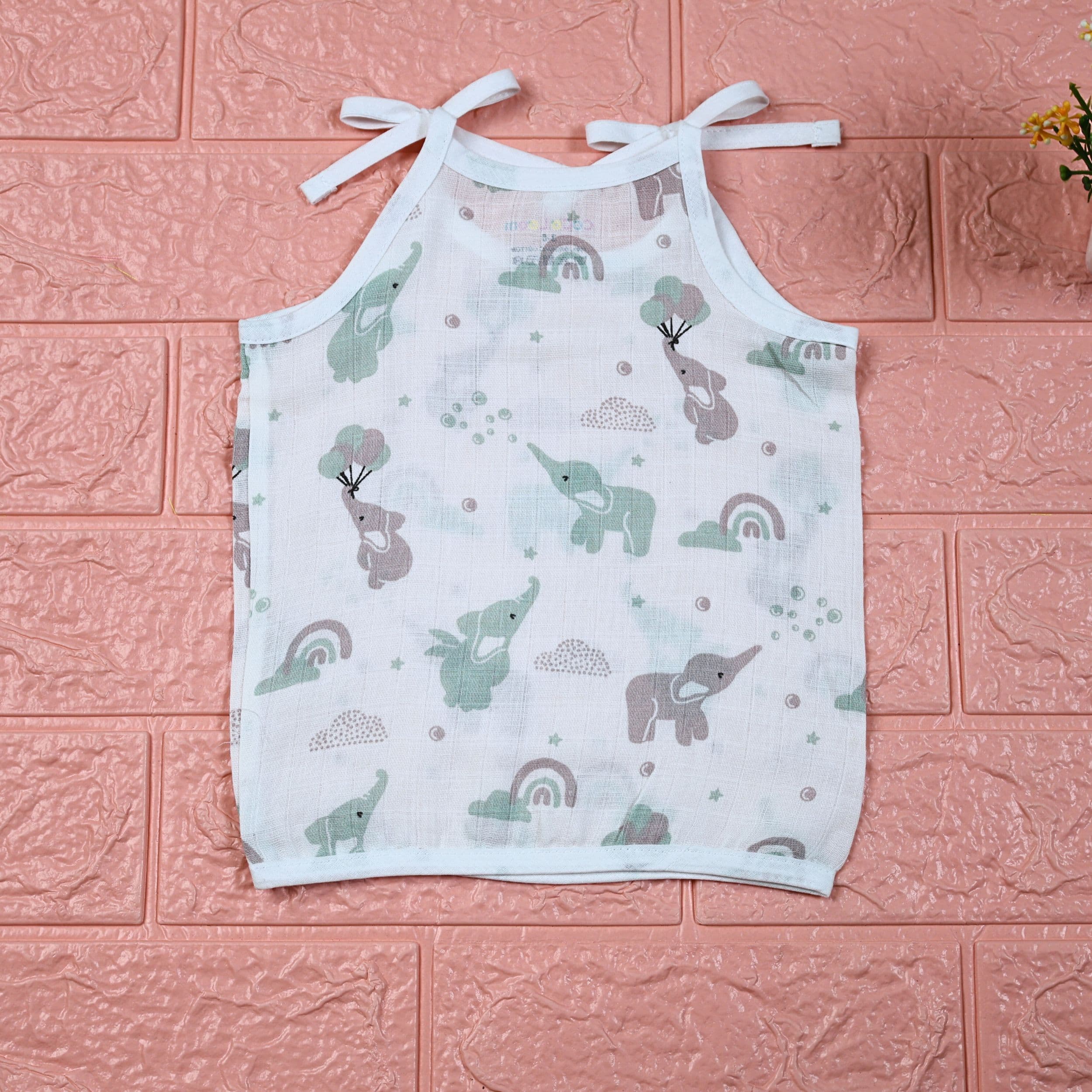 Tiny Tusks baby top in white with shoulder knots, with elephant, clouds and rainbow
 prints in gentle green and brown
 shades.