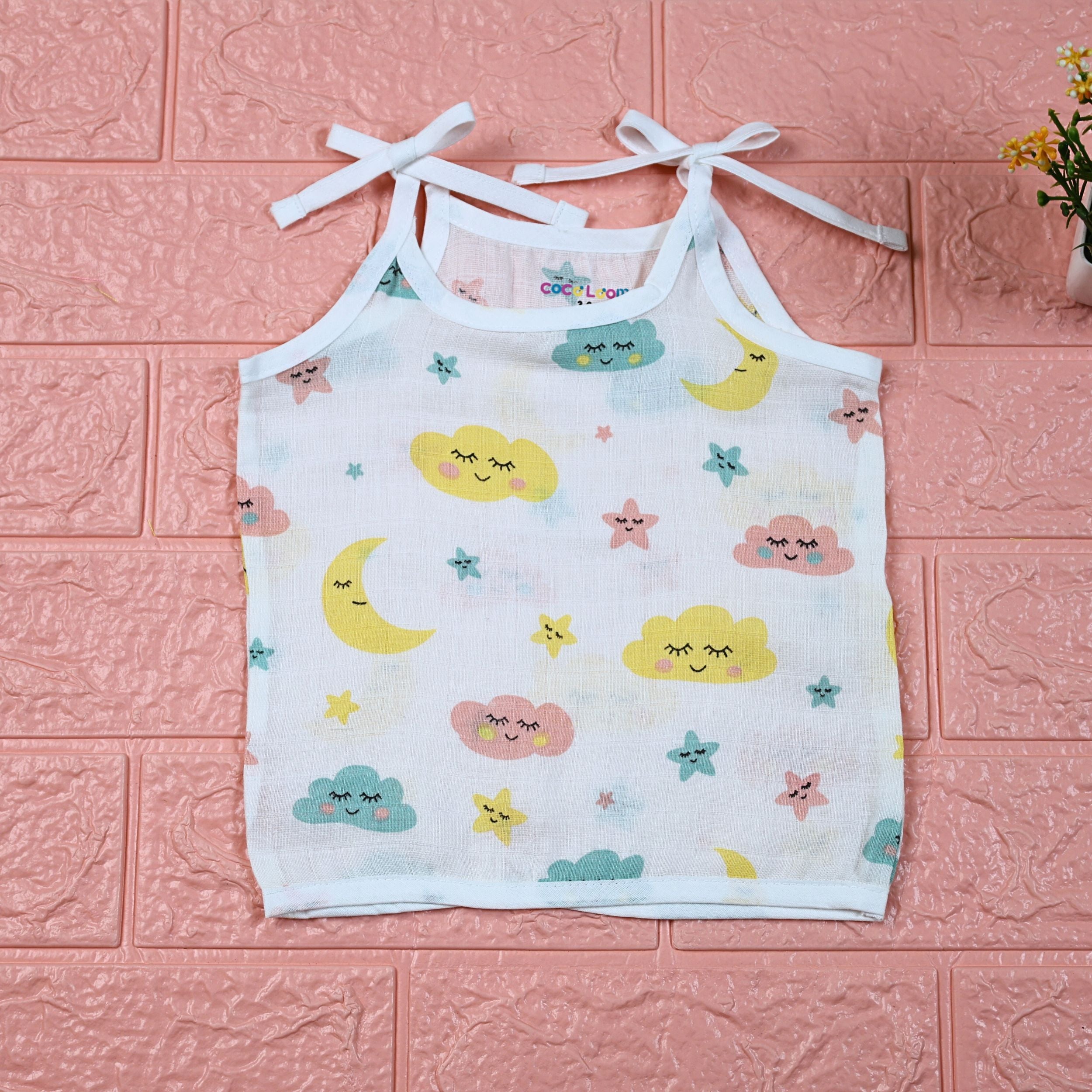 Twinkle Sky baby top in white with tie-up shoulders, printed with pastel cloud, stars and moon.