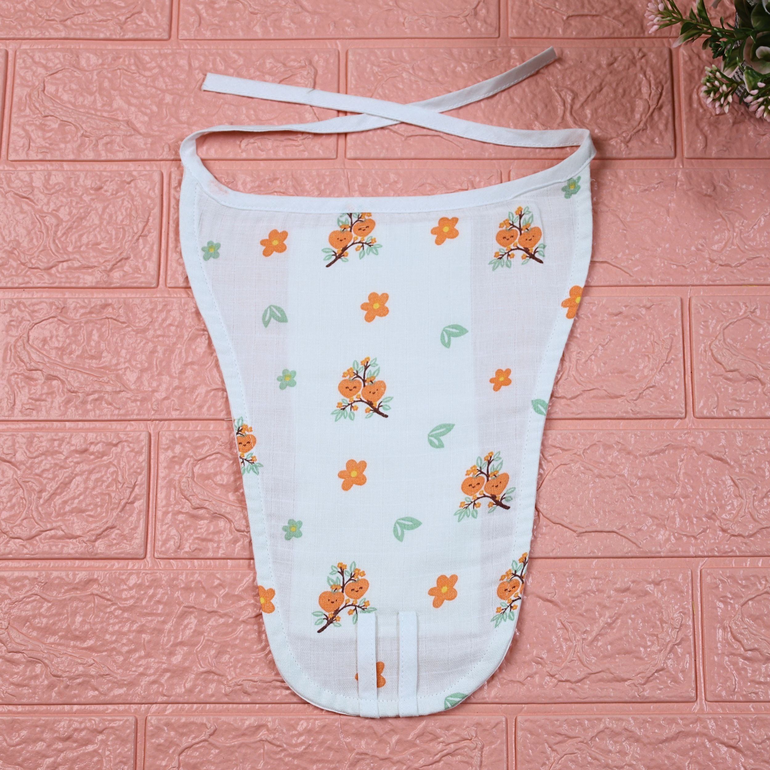 Citrus Bloom Baby nappy in white with tie up knot, printed with orange floral patterns