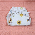 Honey Bloom Baby nappy in white with tie up knot printed with floral and bee pattern