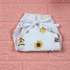 Honey Bloom Baby nappy in white with tie up knot printed with floral and bee pattern