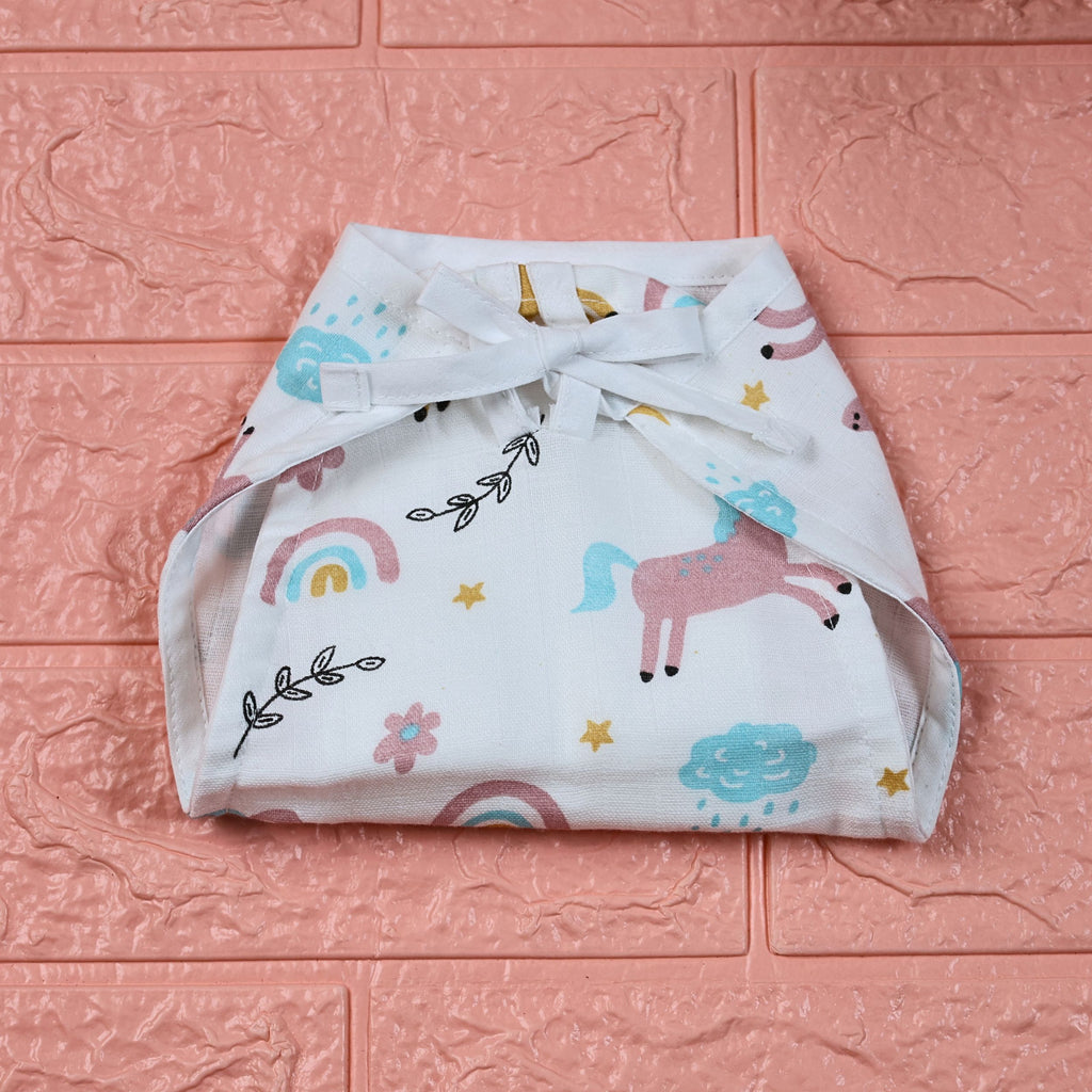 Unicorn Baby nappy in white with tie up knot, printed with unicorn and rainbow patterns