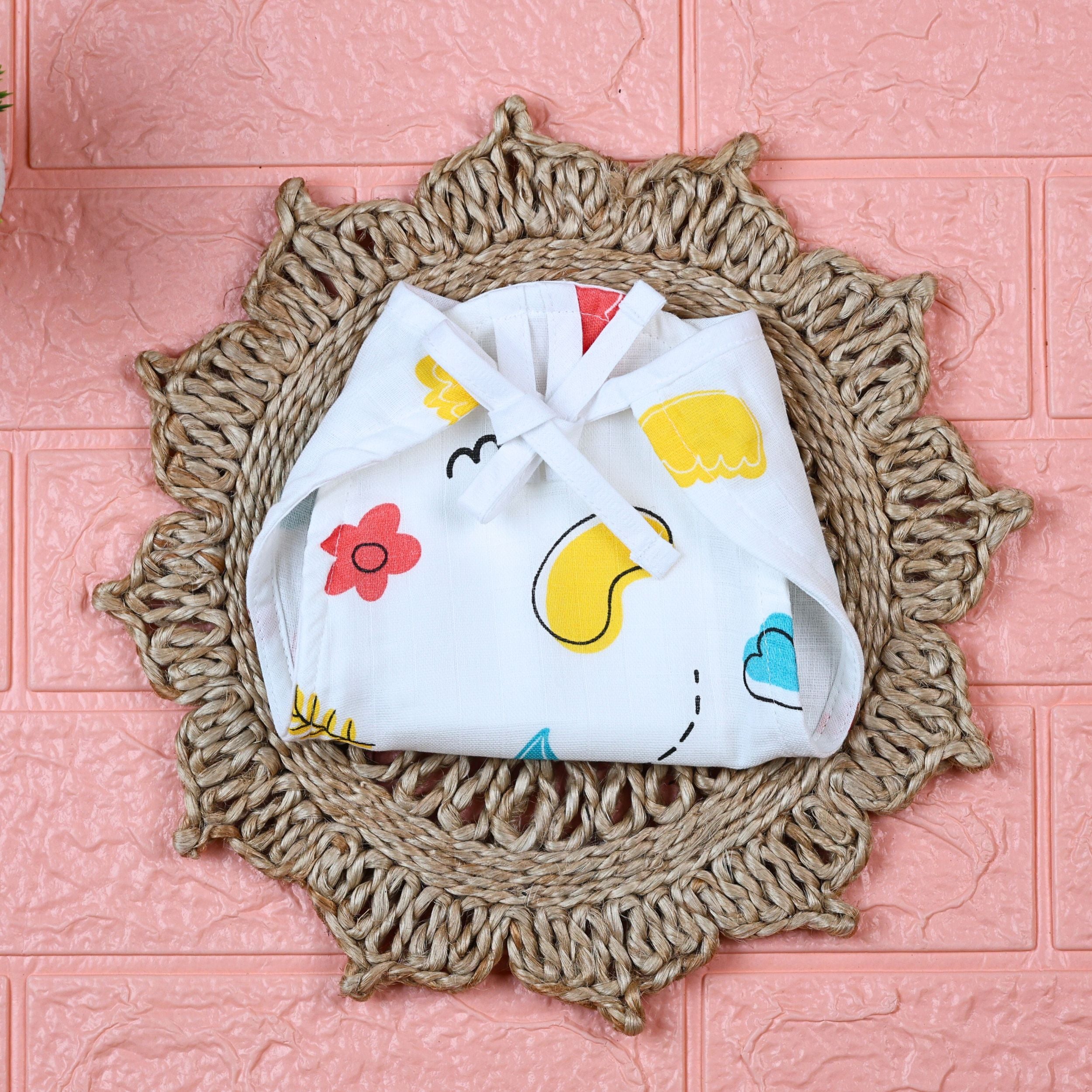 Wild Doodles Baby Nappy in white with tie up knots, printed with yellow, red and pastel green scribble patterns.