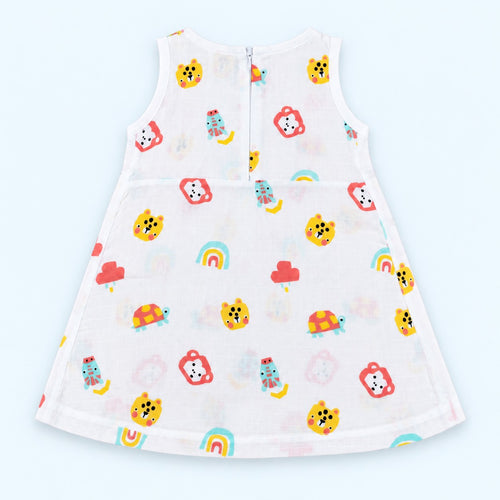 A sleeveless white baby dress with a colorful cartoon pattern of animal faces, rainbows, and small characters, shown from the back on a light blue background.