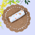 Citrus Bloom Baby Swaddle in white printed with orange floral patterns