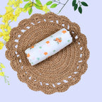 Citrus Bloom Baby Swaddle in white printed with orange floral patterns
