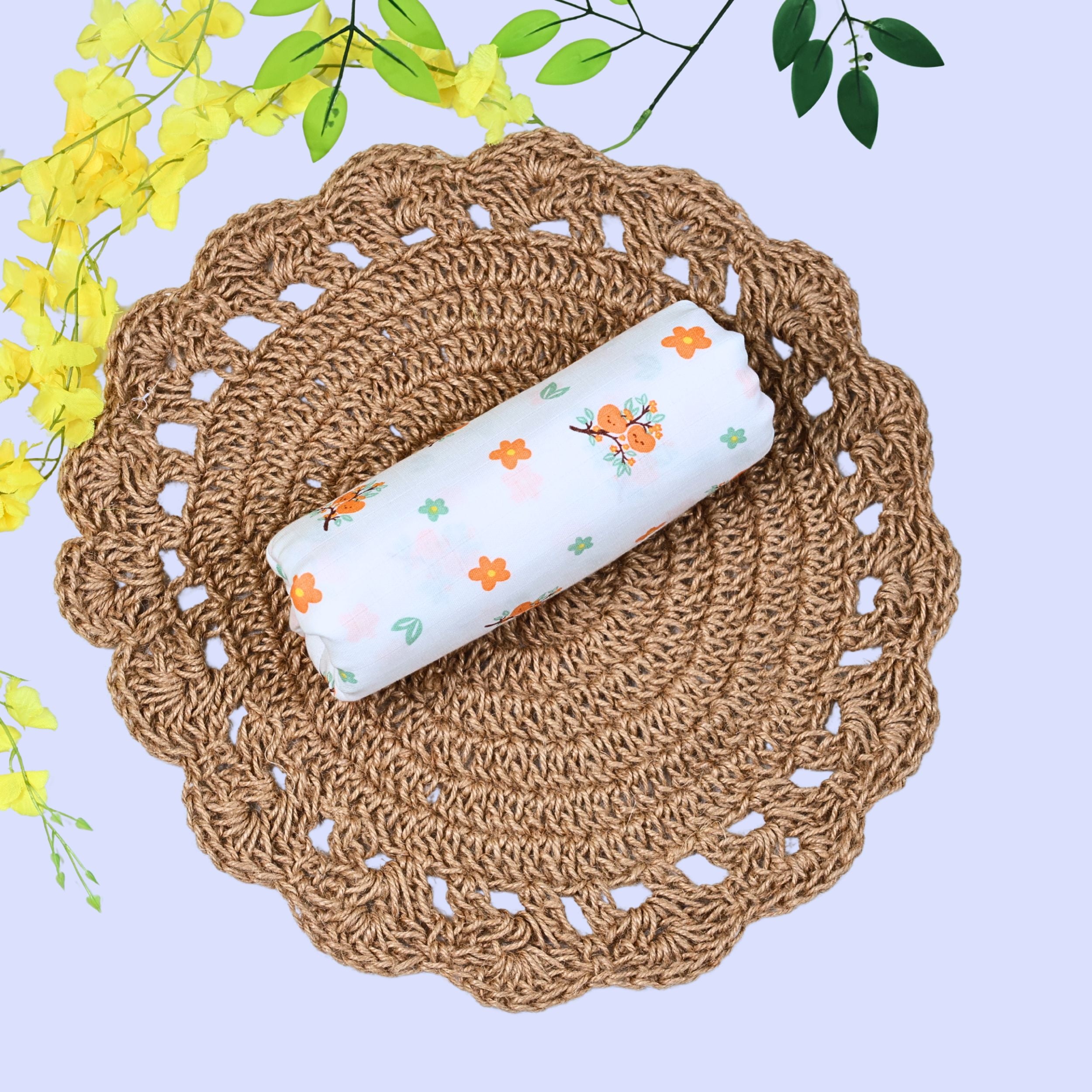 Citrus Bloom Baby Swaddle in white printed with orange floral patterns