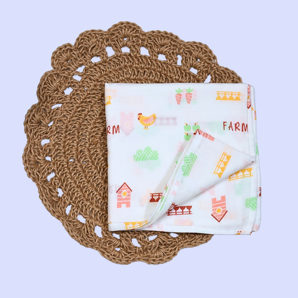 Farm Tales Baby Swaddle in white printed with farm-themed pattern